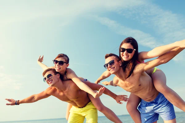 Amici sorridenti divertirsi sulla spiaggia estiva — Foto Stock