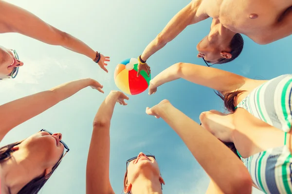 Lachende vrienden in cirkel op zomer strand — Stockfoto