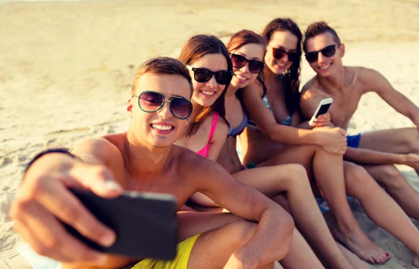Amigos con smartphones en la playa —  Fotos de Stock