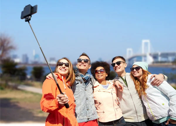 Amigos sonrientes tomando selfie con teléfono inteligente —  Fotos de Stock