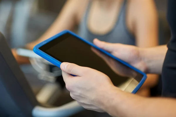 Gros plan des mains de l'entraîneur avec tablette PC dans la salle de gym — Photo