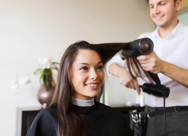 Mujer feliz con estilista haciendo peinado en el salón —  Fotos de Stock