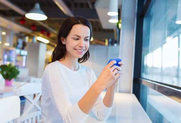 Smiling woman with smartphone at cafe — Stock Photo, Image