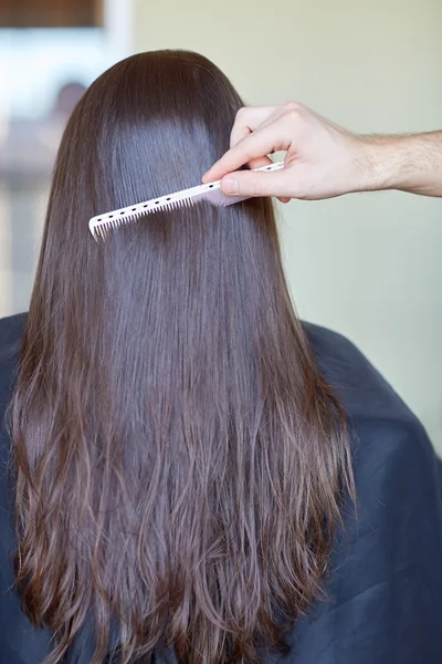 Mano con pettine pettinatura capelli donna al salone — Foto Stock