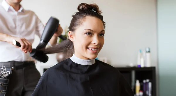 Happy woman with stylist making hairdo at salon — Stock Photo, Image