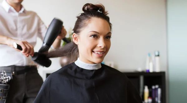 Mulher feliz com estilista fazendo penteado no salão — Fotografia de Stock