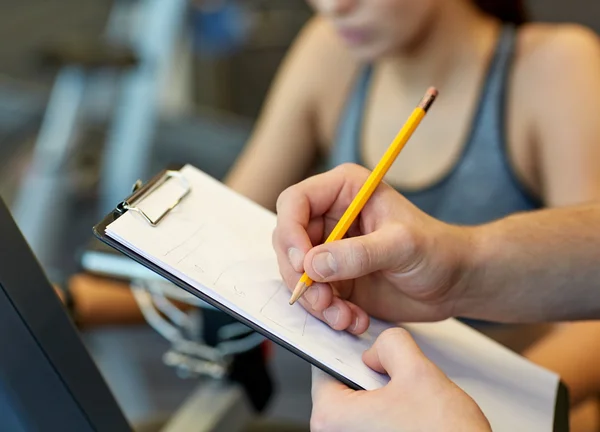 Nahaufnahme von Trainerhänden mit Klemmbrett im Fitnessstudio — Stockfoto