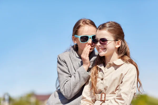 Felice ragazza sussurrando segreto ai suoi amici orecchio — Foto Stock