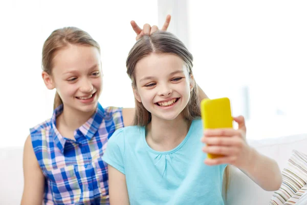 Chicas felices con teléfono inteligente tomar selfie en casa —  Fotos de Stock