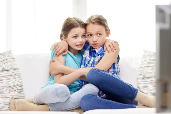 Scared little girls watching horror on tv at home — Stock Photo, Image