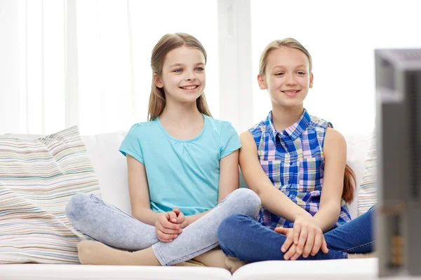 Deux petites filles heureuses regardant la télévision à la maison — Photo