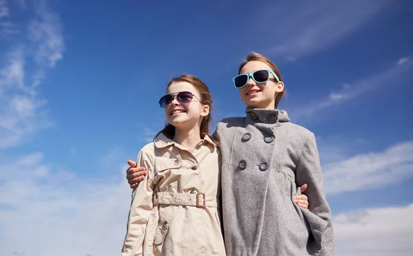 Счастливые маленькие девочки в солнечных очках обнимаются на открытом воздухе — стоковое фото