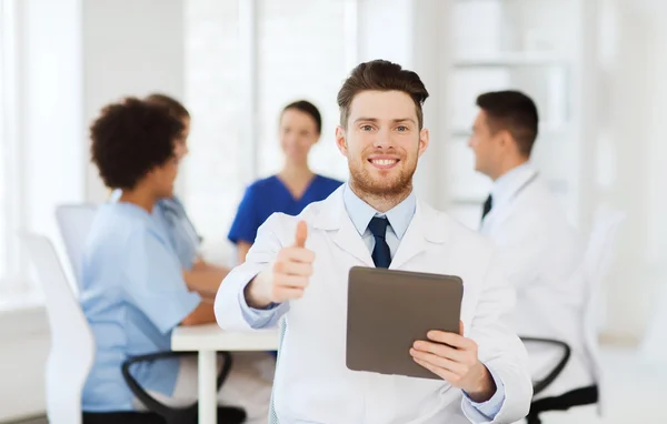 Doctor feliz con la PC tableta sobre el equipo en la clínica —  Fotos de Stock