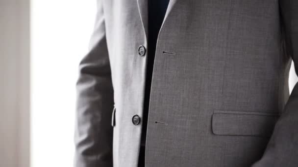 Close up of man in suit fastening button on jacket — Stock Video