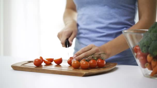 Primer plano de la joven mujer picando tomates en casa — Vídeos de Stock