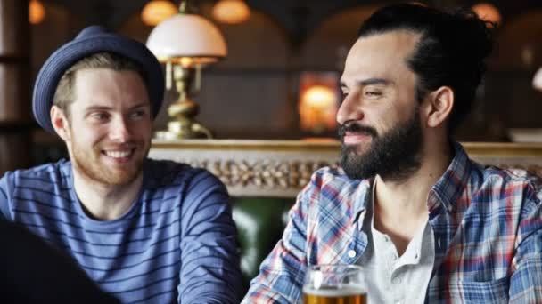 Glückliche männliche Freunde, die Bier in der Bar oder Kneipe trinken — Stockvideo