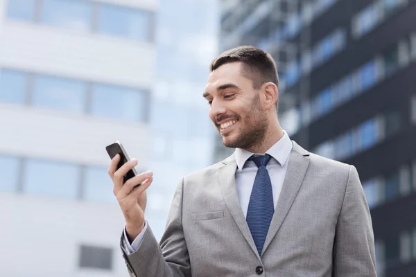 Glimlachend zakenman met smartphone outdoors — Stockfoto