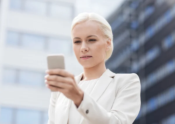 Serious businesswoman with smartphone outdoors — Stock Photo, Image