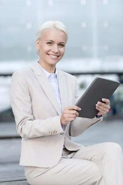 Uśmiechnięta kobieta z komputera typu tablet na zewnątrz — Zdjęcie stockowe