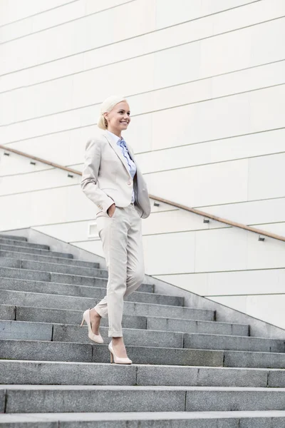 Mladá usměvavá podnikatelka chůzi po schodech — Stock fotografie