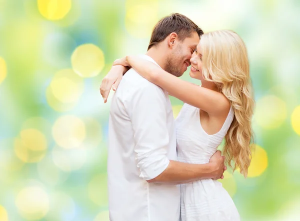 Feliz casal abraçando sobre luzes verdes fundo — Fotografia de Stock