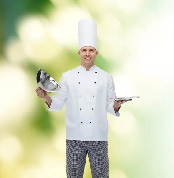 Šťastný muž kuchař kuchař otevření cloche — Stock fotografie