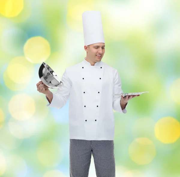 Happy male chef cook opening cloche — Stock Photo, Image