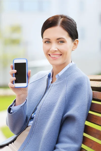 Joven mujer de negocios sonriente mostrando teléfono inteligente — Foto de Stock