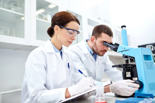 Young scientists making test or research in lab — Stock Photo, Image