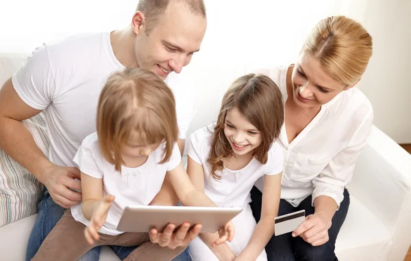 Met tablet pc en creditcard en gelukkige familie — Stockfoto