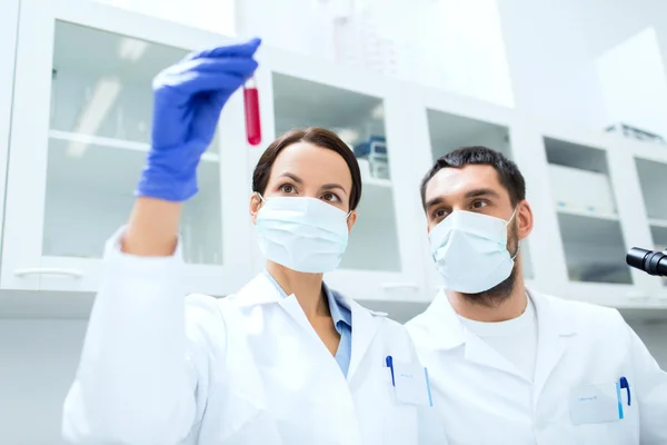 Jovens cientistas que fazem testes ou pesquisas em laboratório — Fotografia de Stock