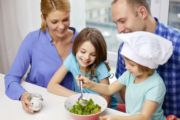 Família feliz com duas crianças cozinhar em casa — Fotografia de Stock