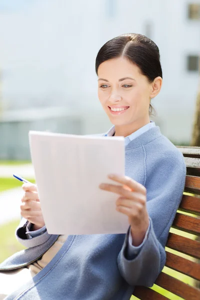 Sonriente mujer de negocios leyendo periódicos al aire libre —  Fotos de Stock