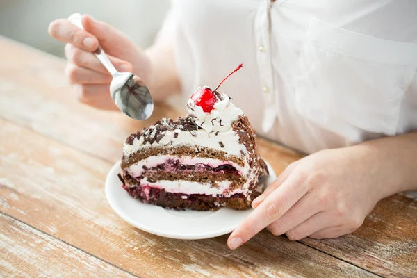 Primer plano de la mujer comiendo pastel de cereza de chocolate — Foto de Stock