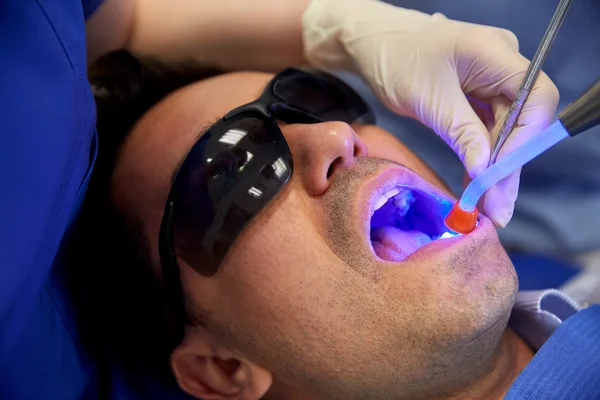 Primer plano del paciente masculino con luz de curado dental —  Fotos de Stock