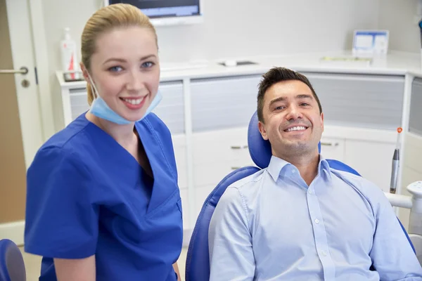 Dentiste féminine heureuse avec patient homme à la clinique — Photo