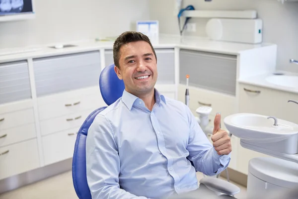 Homem feliz mostrando polegares na clínica odontológica — Fotografia de Stock