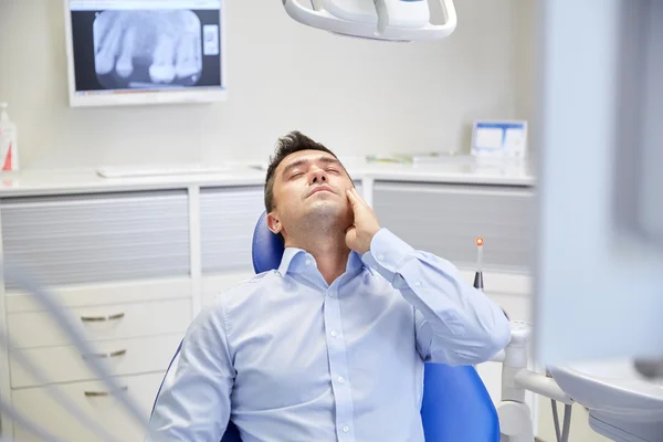 Muž s zuby a sedí na zubařském křesle — Stock fotografie