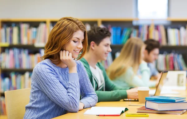 Lycklig student tjej läsa böcker i biblioteket — Stockfoto