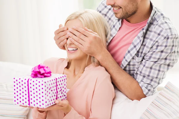 Hombre feliz dando mujer caja de regalo en casa — Foto de Stock