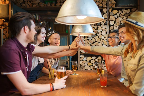 Glückliche Freunde mit Drinks, die High Five an der Bar machen — Stockfoto