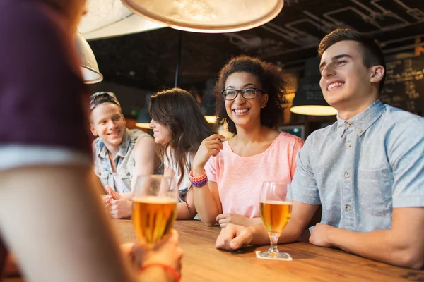 Glückliche Freunde, die Bier trinken und sich an der Bar unterhalten — Stockfoto