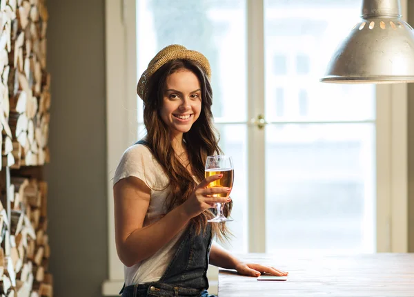 Fröhliche junge Frau trinkt Bier in Bar oder Kneipe — Stockfoto