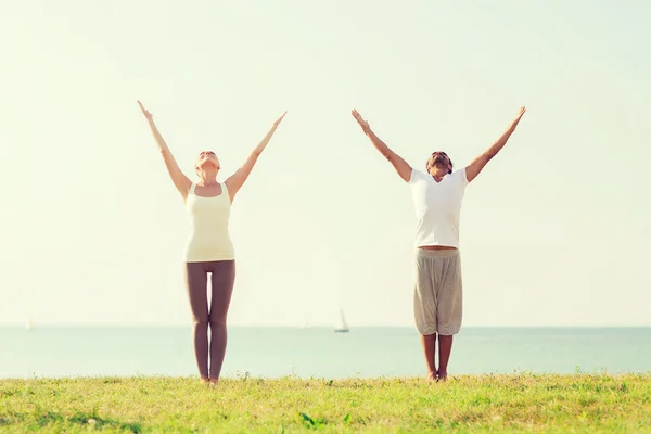 Lächelndes Paar macht Yoga-Übungen im Freien — Stockfoto