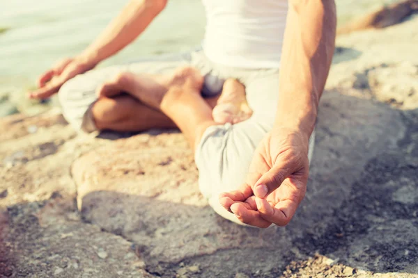 Закрытие человека, делающего упражнения йоги на открытом воздухе — стоковое фото