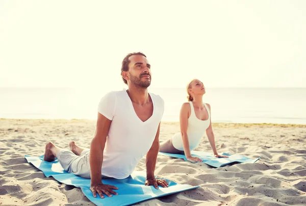 Coppia fare esercizi di yoga all'aperto — Foto Stock