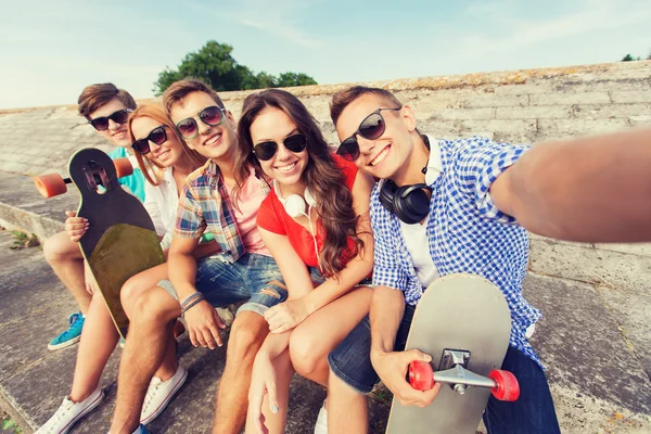 Group of smiling friends with smartphone outdoors — Stock Photo, Image