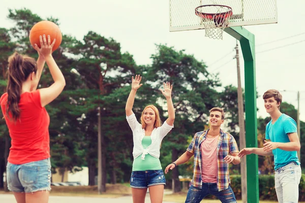 Skupina usměvavá teenagerů hrát basketbal — Stock fotografie