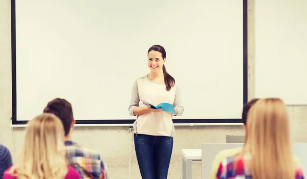 Group of smiling students in classroom — Stock Photo, Image