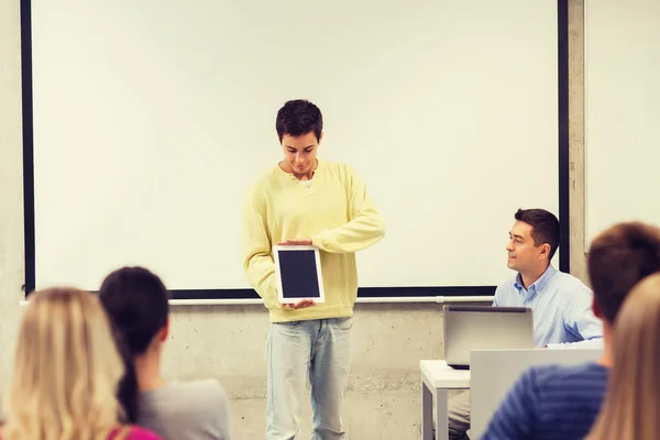 Group of smiling students and teacher in classroom — Stock Photo, Image